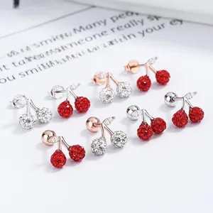 Vue macro de boucles d'oreilles cerises avec pavé de zircons rouges et blancs