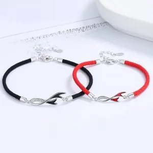 Macro shot of silver koi fish tail bracelets with red and black woven cords and zircons