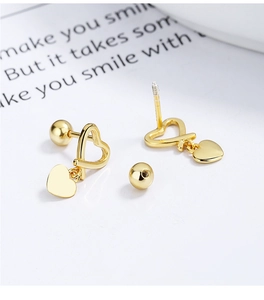 Detail of 925 sterling silver heart studs with screw back closure and golden finish