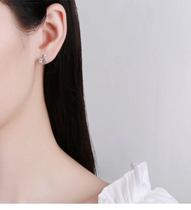 Gros plan d'une boucle d'oreille cerise en argent 925 avec cristaux portées à l'oreille