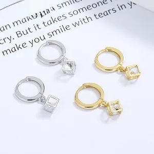 Detail shot of geometric square drop earrings with sparkling cubic zirconia in gold and silver