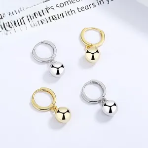 Detailed view of 925 sterling silver hoop earrings with gold and silver sphere charms
