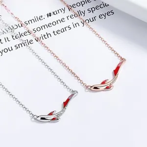 Detail of fish pendants with red enamel and micro-pave zircons on silver chains