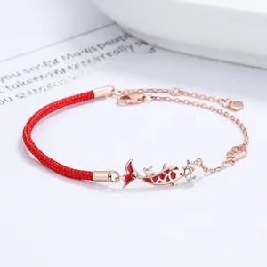 Detailed macro shot of a koi fish charm with red enamel and pavé stones on a rose gold chain