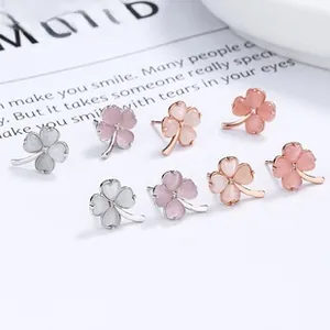Detailed view of four pairs of 925 silver clover earrings with shimmering cat eye stones