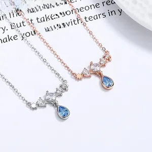 Detailed view of silver and rose gold koi fish necklaces with blue teardrop pendants