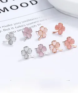 Detail of four-leaf clover earrings with cat eye stones in rose gold and silver finishes