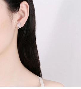 Detail of pink four-leaf clover stud earrings worn by model for elegant style