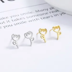 Detail of minimalist 925 silver and gold tulip flower stud earrings on card background