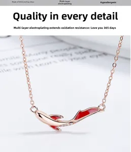 Macro shot of 925 sterling silver koi fish necklace with red enamel and zircon stones