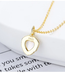 Détail macro du collier cœur en argent S925 avec incrustation de nacre blanche fine