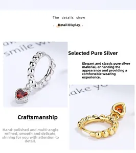 Detail view of heart charms and beaded S925 sterling silver hoop earrings in gold and silver