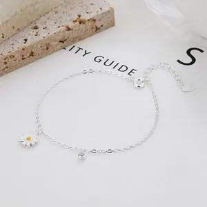 Detail of 925 silver bracelet featuring a small white daisy charm and a sparkling single diamond