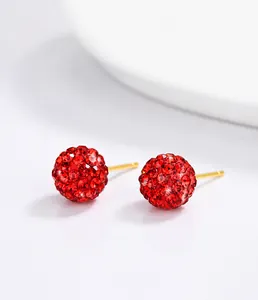 Macro detail of red Shamballa crystal stud earrings with gold S925 sterling silver posts