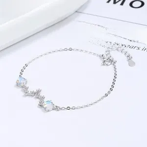 Macro detail of 925 sterling silver daisy bracelet with opal stones and heart pendant