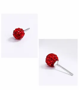 Close-up of S925 sterling silver ear needle and red crystal disco ball stud earrings