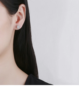 Close-up of Shamballa-style sparkling pave crystal ball earrings worn on the ear