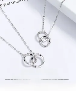 Detailed view of interconnected 925 sterling silver Möbius double ring necklaces for couples