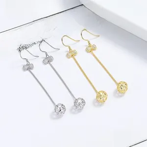 Macro view of crystal bow earrings with long chain tassels in gold and silver finish