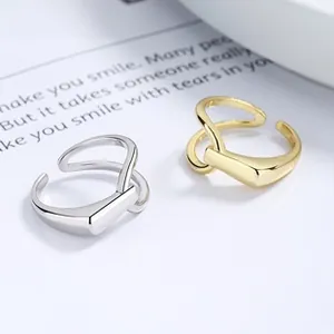 Detail of 925 sterling silver interlocking rings in gold and silver finish with wide geometric bands