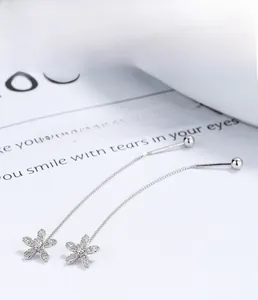 Detail of S925 sterling silver long tassel earrings with sparkling zircon flower charms