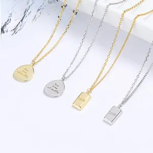 Detailed view of silver and gold pendants engraved with LUCK and You Are My Smile text