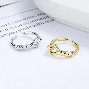 Detail of twisted knot S925 sterling silver rings in gold and silver finishes