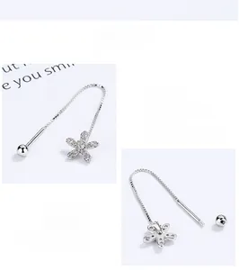 Macro detail of 925 sterling silver flower tassel earrings with zircon studs