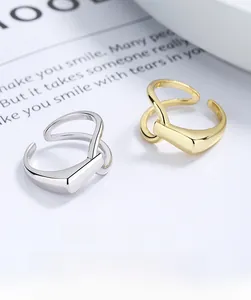 Macro detail of intertwined silver and gold geometric open rings on a fashion magazine