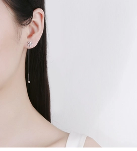 Detail of 925 sterling silver flower tassel ear threader with zircon on model ear