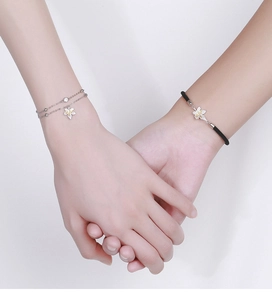 Close-up of 925 silver flower bracelets on couple holding hands with minimalist style