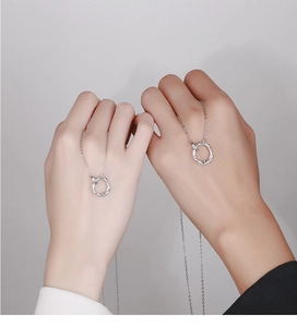 Close-up of a couple wearing 925 silver necklaces with twisted rope ring pendants