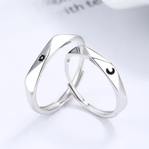 Macro shot of sun and moon engraved patterns on minimalist silver Mobius rings