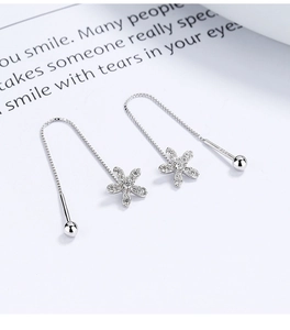 Close-up of 925 sterling silver flower tassel earrings with shimmering zircon petals