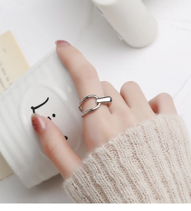 Close-up of interlocking 925 sterling silver rings worn on finger for an elegant style