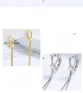 Detailed close-up of 925 silver knotted hoop earrings with long metallic tassel fringe