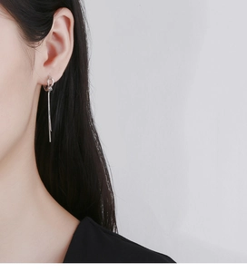 Detail of 925 sterling silver long tassel earrings on model with a minimalist knot design