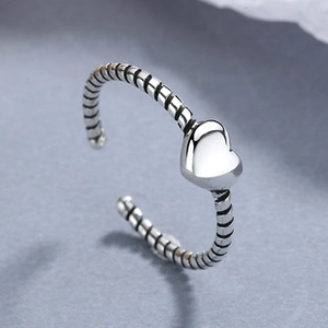 Close-up of 925 sterling silver heart ring with twisted band and adjustable open design