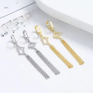 Detailed macro view of 925 silver and gold tassel drop earrings with sparkling rhinestones