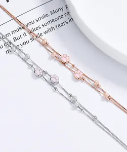 Detalle de pulseras de pata de gato en plata y oro rosa con cuentas mate sobre una revista