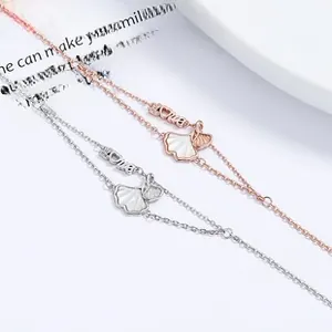 Détail de bracelets lapin en argent et or rose avec pendentif nacre et étiquette Love