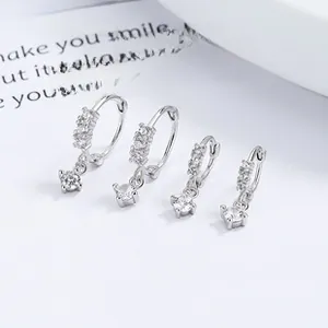 Macro shot of 925 sterling silver hoop earrings with round cubic zirconia pendants