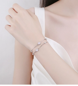 Primer plano de una pulsera de doble capa de plata 925 con dijes de patas rosas y cuentas