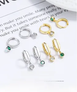 Detail of S925 silver hoop earrings with clear and emerald green cubic zirconia charms