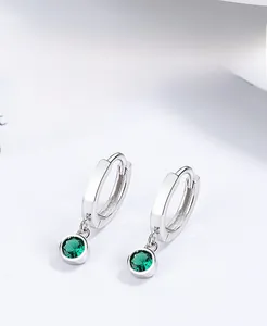 Detail of S925 silver hoop earrings with a round green gemstone in polished finish