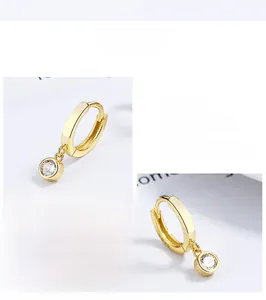 Macro detail of 925 sterling silver gold plated hoop earring with round zircon stone