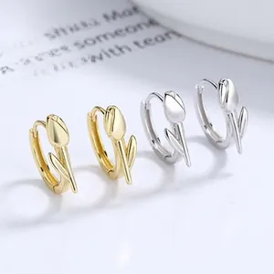 Detail of tulip earrings in gold and silver finish with elegant petal and leaf accents