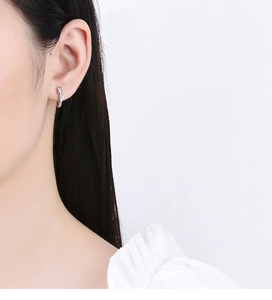 Detail of 925 sterling silver tulip hoop earring on ear with elegant floral design