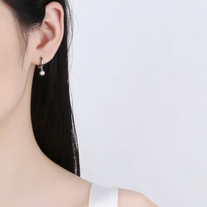 925 sterling silver huggie earrings with round zircon pendant on a female model