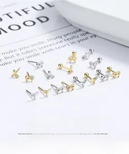 Macro detail of 925 sterling silver fishtail and bow earrings in gold and silver
